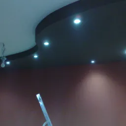 Wykończony sufit podwieszany z oświetleniem punktowym, widoczna drabina malarska i fragment żarówki na kablach.